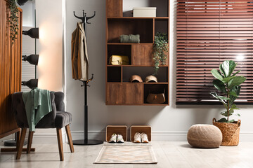 Shelving unit with different accessories and shoes in hallway