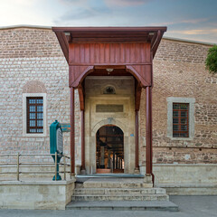 Entrance of Alaaddin Keykubad Mosque, where the intricate stonework and wooden elements reflect the rich history of Konya, Turkey, bathed in soft evening light
