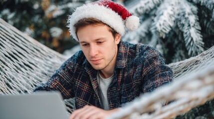 Holiday productivity, man in plaid and santa hat working on laptop