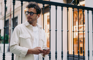 Caucasian Man with smart glasses and wireless earphones using smartphone. Concept of modern...