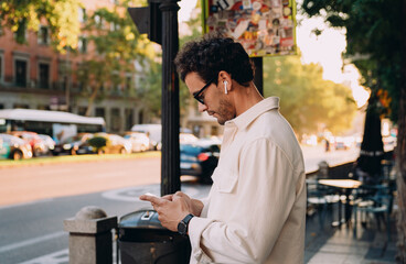modern professional checks his smartphone on busy city street, staying updated with financial...