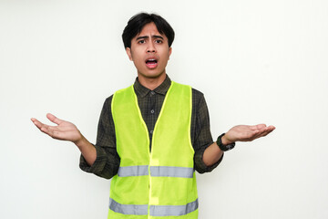 Young Asian engineer looks confused, hand raised in shock. Isolated portrait capturing a moment of...