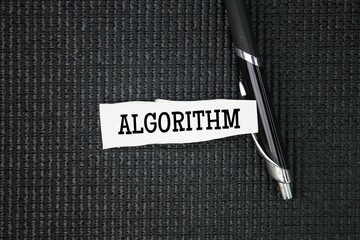 Pen and torn paper with the word algorithm. a process or set of rules to be followed in...