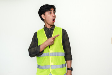 Portrait of a Asian construction worker man pointing sideways with a funny wow expression, isolated...
