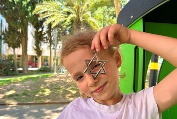 Portrait of a Jewish girl with a Star of David. Repatriation for families, learning Hebrew,...