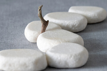 Empty stone podium, pieces of snag on grey background. Minimalist eco backdrop. Round natural rocks and snags. Pedestal for product advertising. Wabi sabi concept. Copy space, front view.