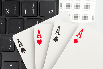 An image showcases playing cards with the ace of spades, arranged near a computer keyboard, blending gaming and technology The concept suggests multitasking, strategy, decision-making, and the inter