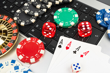 A stock image displays various casino items arranged on a white surface, resembling a keyboard layout Items include red chips, dice, playing cards, and slot machine tokens The context suggests gamb