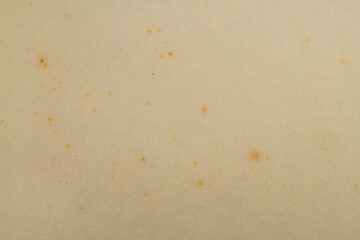 A vintage watch with a faded yellow face against a beige background, exuding elegance and history...