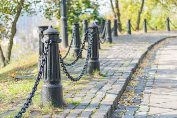 A serene, timeless scene showcases an old stone pathway leading through a lush park or garden,...