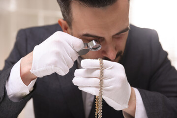 Appraiser evaluating luxury necklace indoors, closeup view