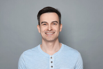 Fototapeta premium Smiling man after shaving on grey background