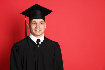 Happy student after graduation on red background. Space for text