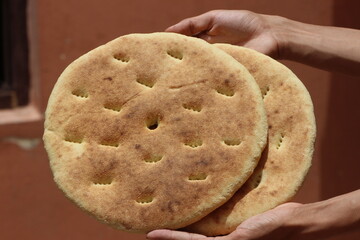 Hands holding a traditional moroccan bread, Khobz Close Up