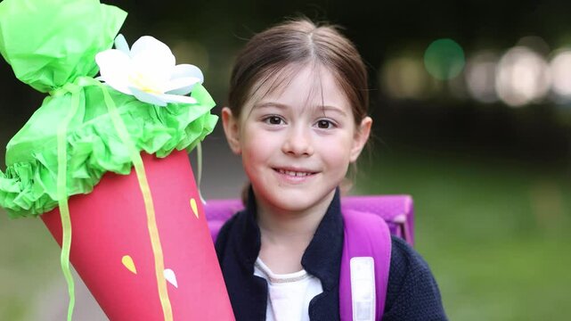 happy little girl schoolgirl first grader with schultute and backpack. portrait of child outdoor. back to school in Germany