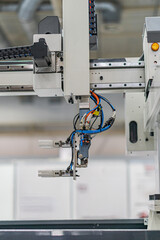Close-up view of an industrial robot, predominantly white, grey, and black in color, with visible wires and cables No people present Even lighting without harsh shadows Standard photograph style