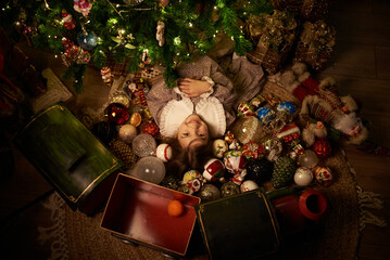 cute girl at cozy home under decorated christmas tree