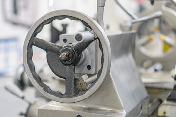 Industrial machine parts, gray and metallic tones, large gear or sprocket, flange, factory or workshop setting, mechanical structure, muted colors, no people, no text