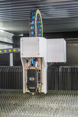 Industrial robotic arm system in an industrial setting, constructed from metal, features blue-tipped joints likely sensors or motors Image is dimly lit, focusing on design and construction without a