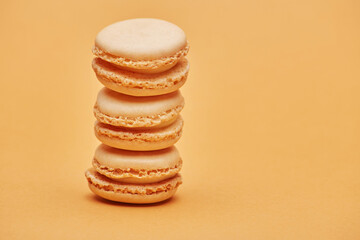 Stack of vanilla light beige color biscuits macaron cookies isolated on the bright solid fond plain...
