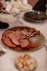 A table covered with various foods, a meat and sausage plate in the center