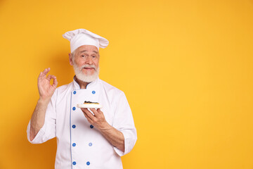 Professional pastry chef with delicious tart showing ok gesture on orange background, space for text