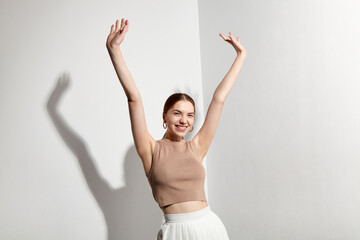 The happy woman smiles and raises her hands up