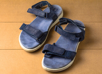 Used blue women sandals on wooden background top view fashion footwear closeup