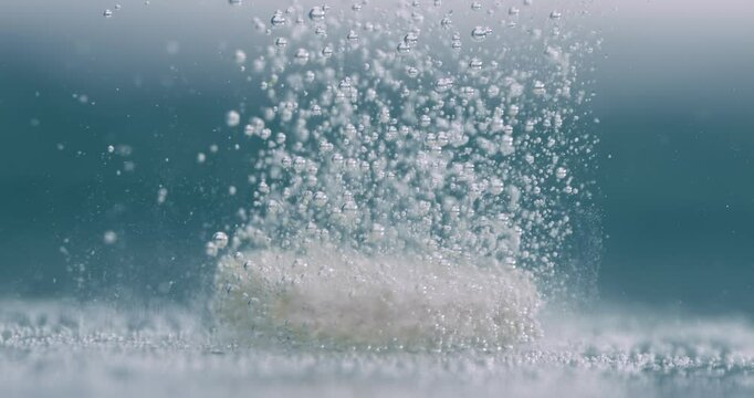Extreme Close-up effervescent tablet, pill bubbling underwater. Shot on super slow motion camera 1000 fps.