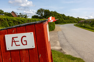 Mors, Denmark A box by the side of a rural road and a sign for eggs in Danish. © Alexander