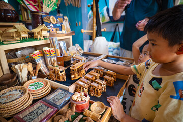 Kid enjoy buy handmade toy in souvenir shop floating market