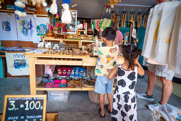 Kid enjoy buy handmade toy in souvenir shop floating market