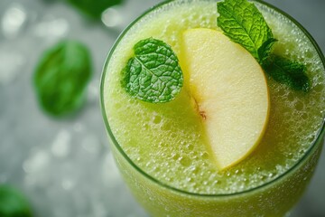 Refreshing green smoothie with apple slices and mint garnish.