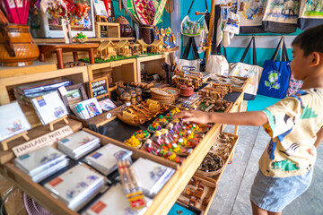 Kid enjoy buy handmade toy in souvenir shop floating market
