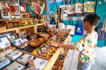 Kid enjoy buy handmade toy in souvenir shop floating market