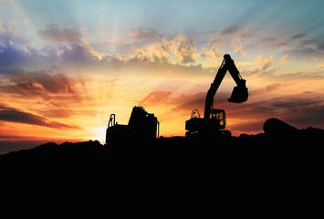 Crawler excavators silhouette are digging the soil in the construction site. on  sunbeam background