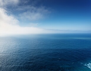 Obraz premium a breathtaking seascape featuring an expansive ocean shrouded in a soft ethereal haze illuminated by dramatic lighting and a calming negative space