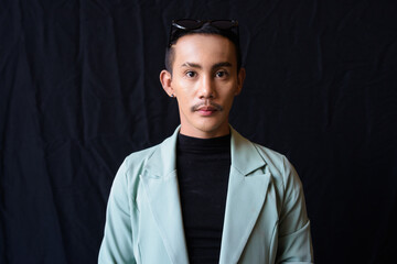 Portrait of nonbinary genderfluid young Asian gay man in studio