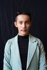 Portrait of nonbinary genderfluid young Asian gay man in studio