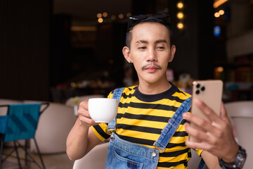 Portrait of nonbinary genderfluid young Asian gay man in coffee shop