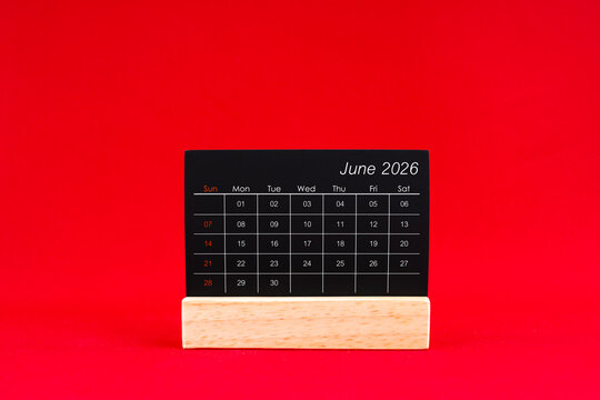 June 2026 chalkboard calendar on red color background.