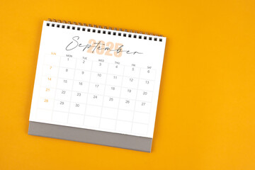 Top view of September 2025 desk calendar on yellow color background.