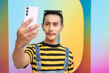 Empowering portrait of nonbinary genderfluid young Asian gay man taking selfie