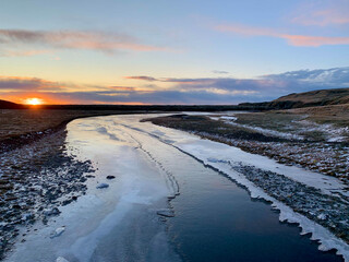Sunset along a semi frozen river