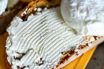 Bread toast is smeared with cottage cheese cream. Close-up.