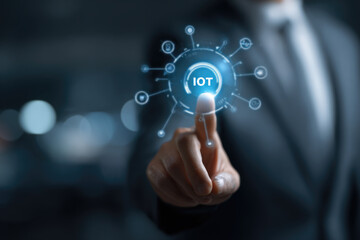 Fototapeta premium Smart business IOT, internet of things concept. Businessman touching IOT icon on virtual screen, connected internet network to access AI intelligence, business analytics, internet investing