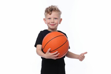 Little boy with basketball ball showing thumbs up on white background
