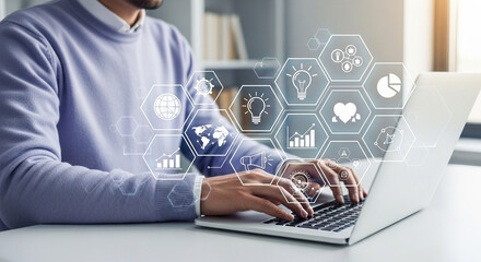 Man typing on laptop with digital icons overlaying the screen in a bright office setting indoors