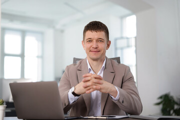 Portrait of handsome man at desk in office