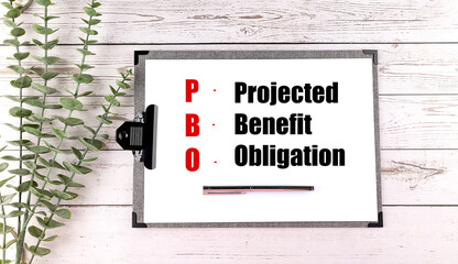 Clipboard with abbreviation PBO and its meaning projected benefit obligation on wooden background